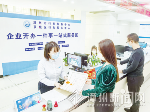 　经营者在我市“企业开办一件事一站式”服务专区领取营业执照和免费印章 吴仕龙 摄