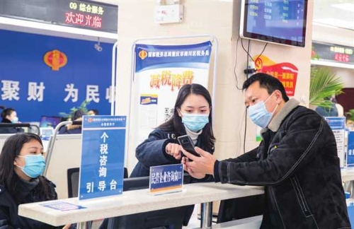 税务工作人员为办事群众讲解办税服务手机操作流程